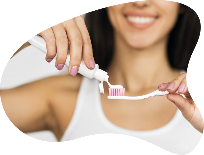 A Woman Putting Toothpaste On A Toothbrush
