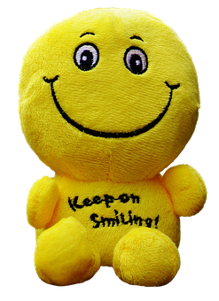 A Yellow Stuffed Animal With A Smiley Face