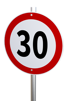 A Red And White Road Sign With Black Numbers