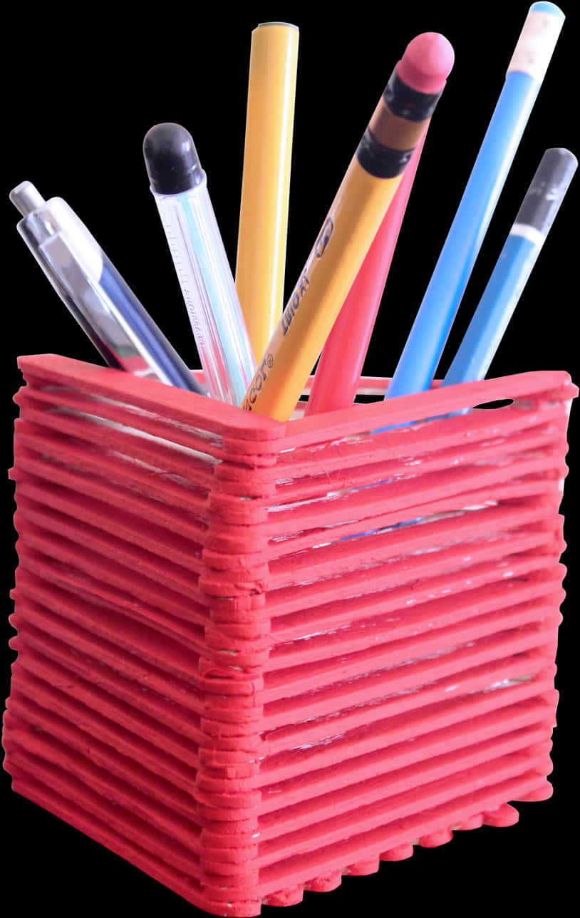 A Red Pencil Holder With Pens In It