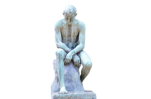 A Statue Of A Man Sitting On A Rock