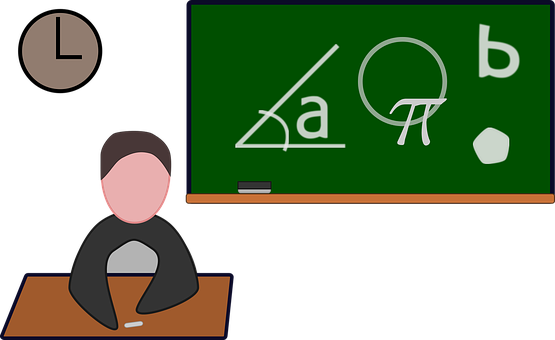 A Person Sitting At A Desk In Front Of A Chalkboard