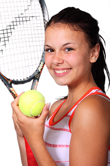 A Woman Holding A Tennis Racket And A Ball