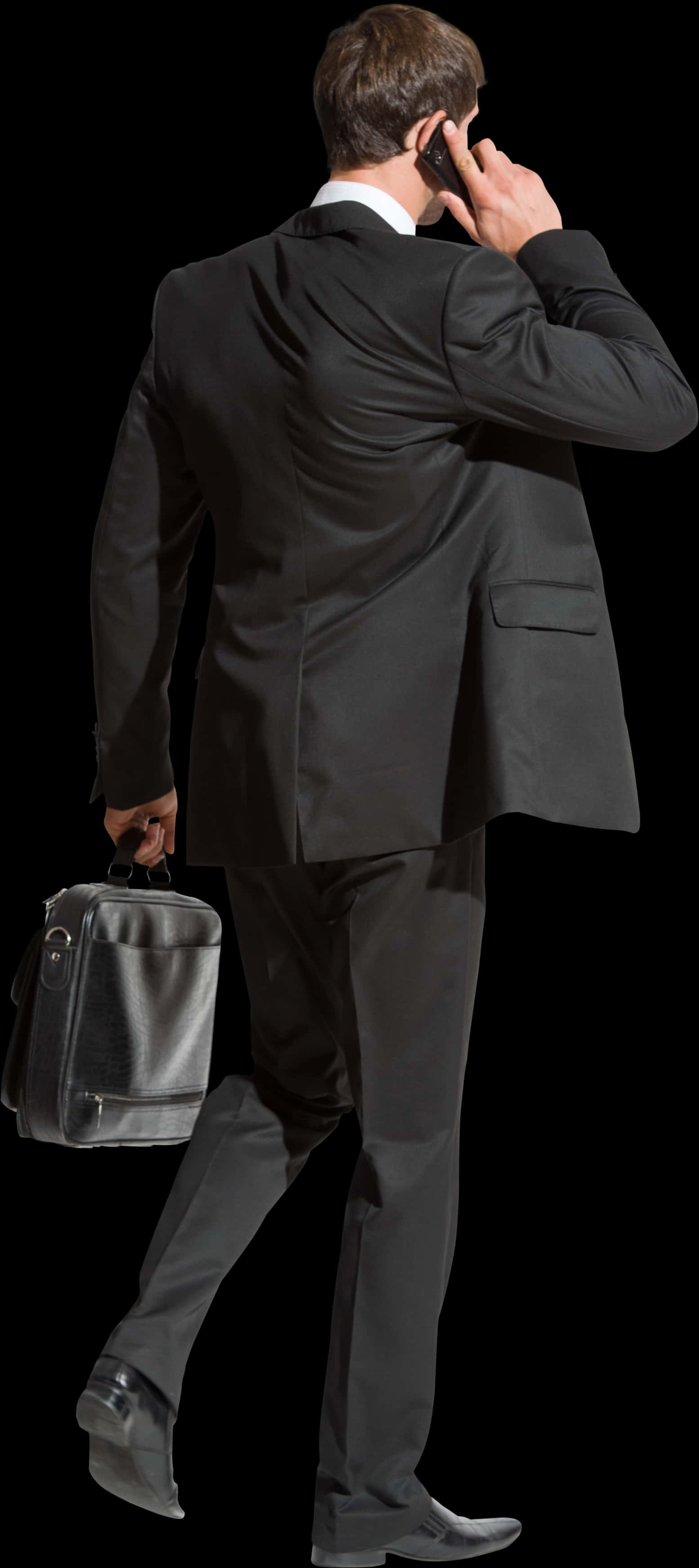 A Man In A Suit Carrying A Suitcase
