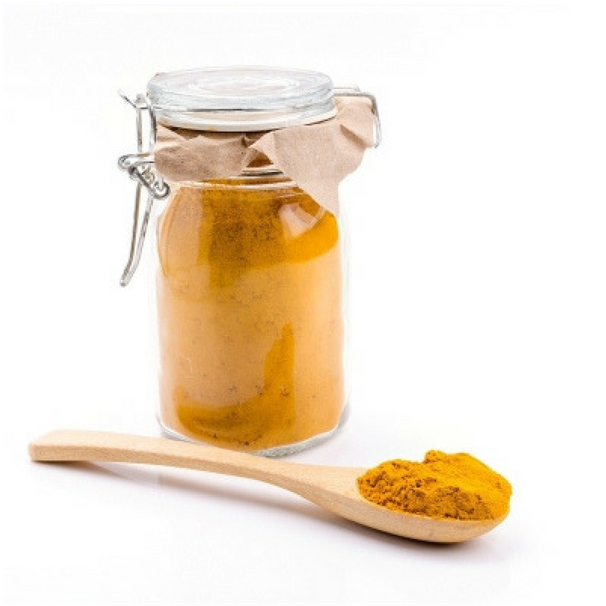 A Jar Of Yellow Powder And A Wooden Spoon