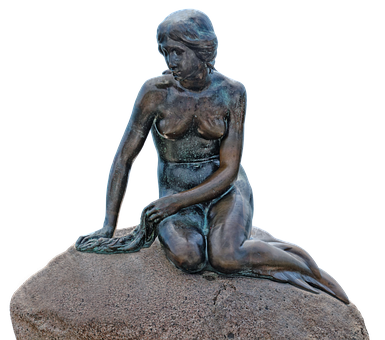 A Statue Of A Woman Sitting On A Rock
