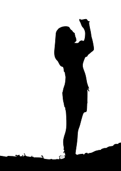 A Silhouette Of A Woman Holding Up Her Hand