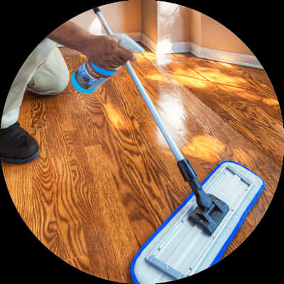 A Person Cleaning A Hardwood Floor